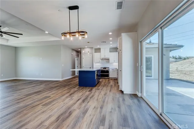 a view of a room with wooden floor and kitchen view