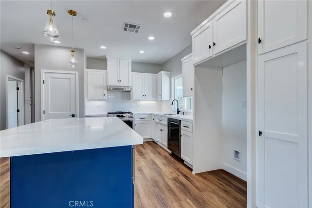 a kitchen with kitchen island a sink stainless steel appliances and cabinets