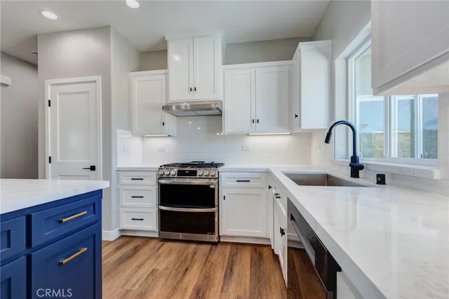 a kitchen with stainless steel appliances granite countertop a stove a sink and a refrigerator