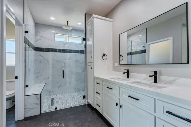 a bathroom with a double vanity sink mirror and shower