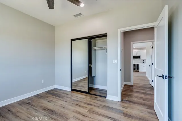 a view of a kitchen with wooden floor and a ceiling fan