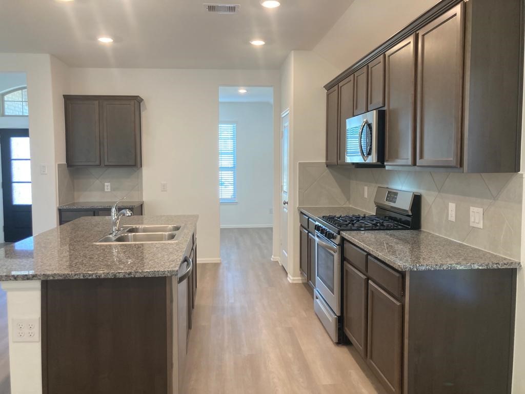 3731 Lion Creek Rosenberg, TX 77469 - Photo 2 of 13 a kitchen with stainless steel appliances granite countertop a sink stove and cabinets