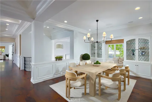 a view of a dining room and livingroom with furniture wooden floor a chandelier