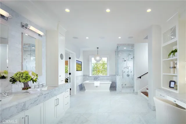 a large bathroom with a granite countertop tub a mirror a shower and a double vanity sink
