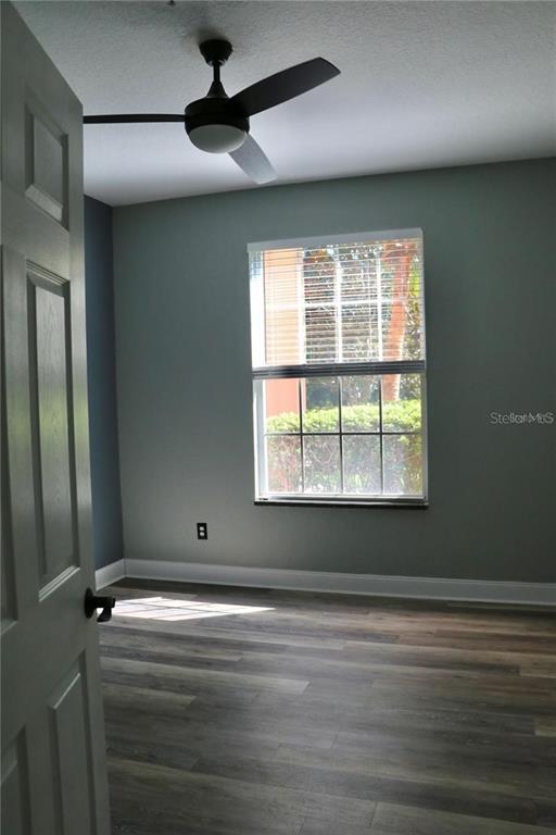 13548 Turtle Marsh Loop, Unit 413 Orlando, FL 32837 - Photo 13 of 27 an empty room with wooden floor and windows
