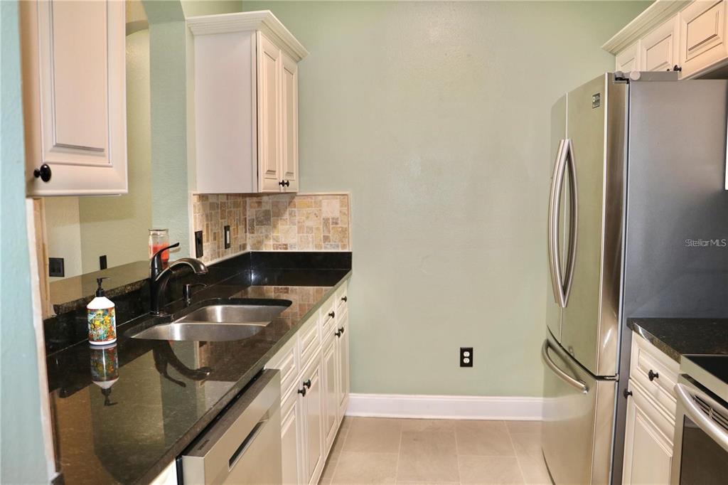 13548 Turtle Marsh Loop, Unit 413 Orlando, FL 32837 - Photo 16 of 27 a kitchen with a sink and a refrigerator
