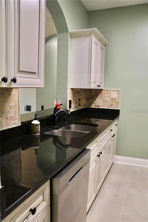13548 Turtle Marsh Loop, Unit 413 Orlando, FL 32837 - Photo 4 of 27 a kitchen with a sink dishwasher and cabinets