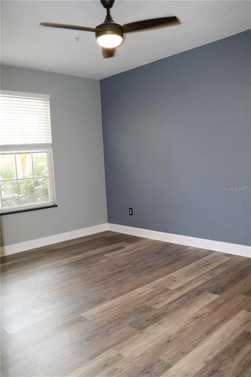 13548 Turtle Marsh Loop, Unit 413 Orlando, FL 32837 - Photo 7 of 27 an empty room with wooden floor fan and windows