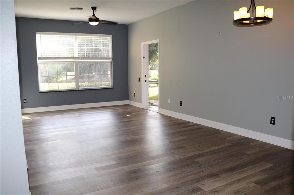 13548 Turtle Marsh Loop, Unit 413 Orlando, FL 32837 - Photo 9 of 27 an empty room with wooden floor chandelier and windows