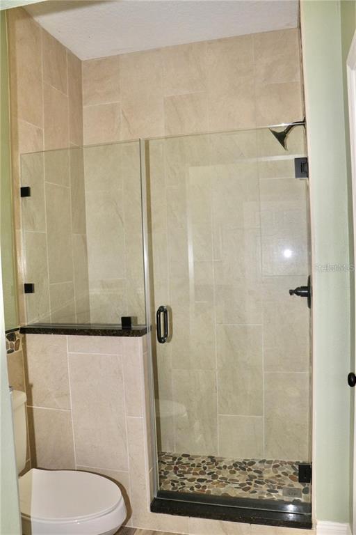 13548 Turtle Marsh Loop, Unit 413 Orlando, FL 32837 - Photo 10 of 27 a bathroom with a toilet and a shower