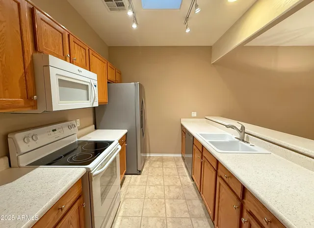 a kitchen with stainless steel appliances a refrigerator and a sink