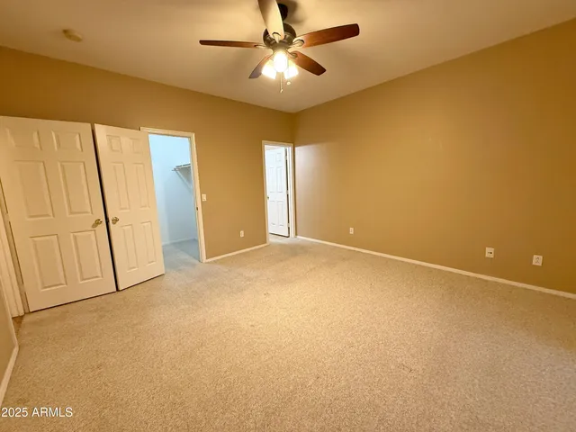 a view of an empty room with a ceiling fan