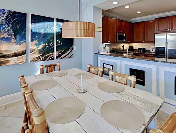 2421 West County Highway 30A, Unit E303 Santa Rosa Beach, FL 32459 - Photo 11 of 23 a kitchen with stainless steel appliances kitchen island granite countertop a table chairs sink and cabinets