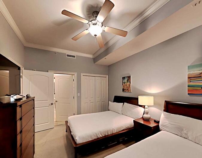 2421 West County Highway 30A, Unit E303 Santa Rosa Beach, FL 32459 - Photo 21 of 23 a bedroom with a bed and a chandelier