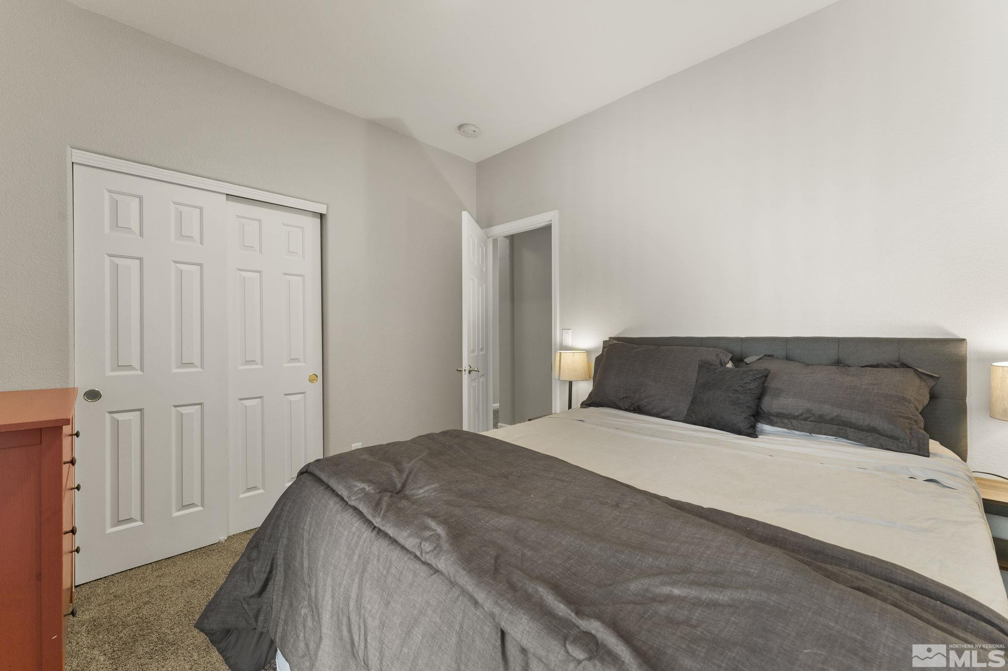 10640 Arbor Way Reno, NV 89521 - Photo 19 of 37 a bedroom with a large bed and a chandelier