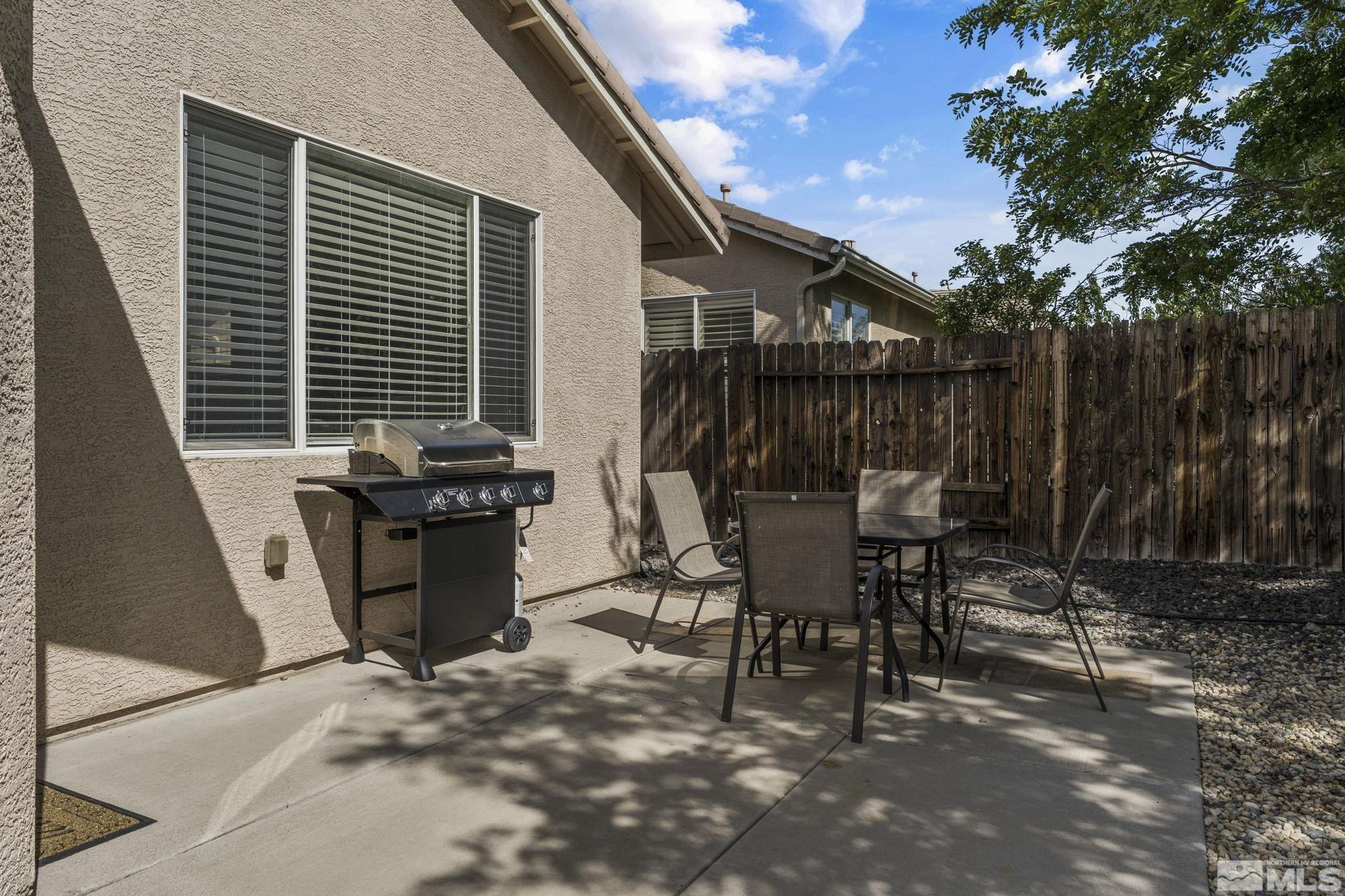 10640 Arbor Way Reno, NV 89521 - Photo 35 of 37 a view of a patio with table and chairs with wooden fence and plants