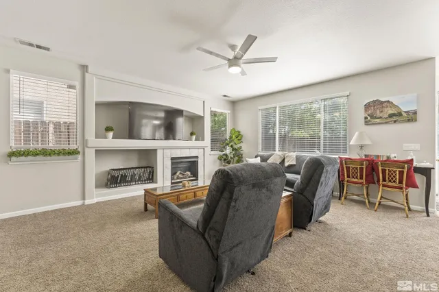a living room with furniture a fireplace and a floor to ceiling window