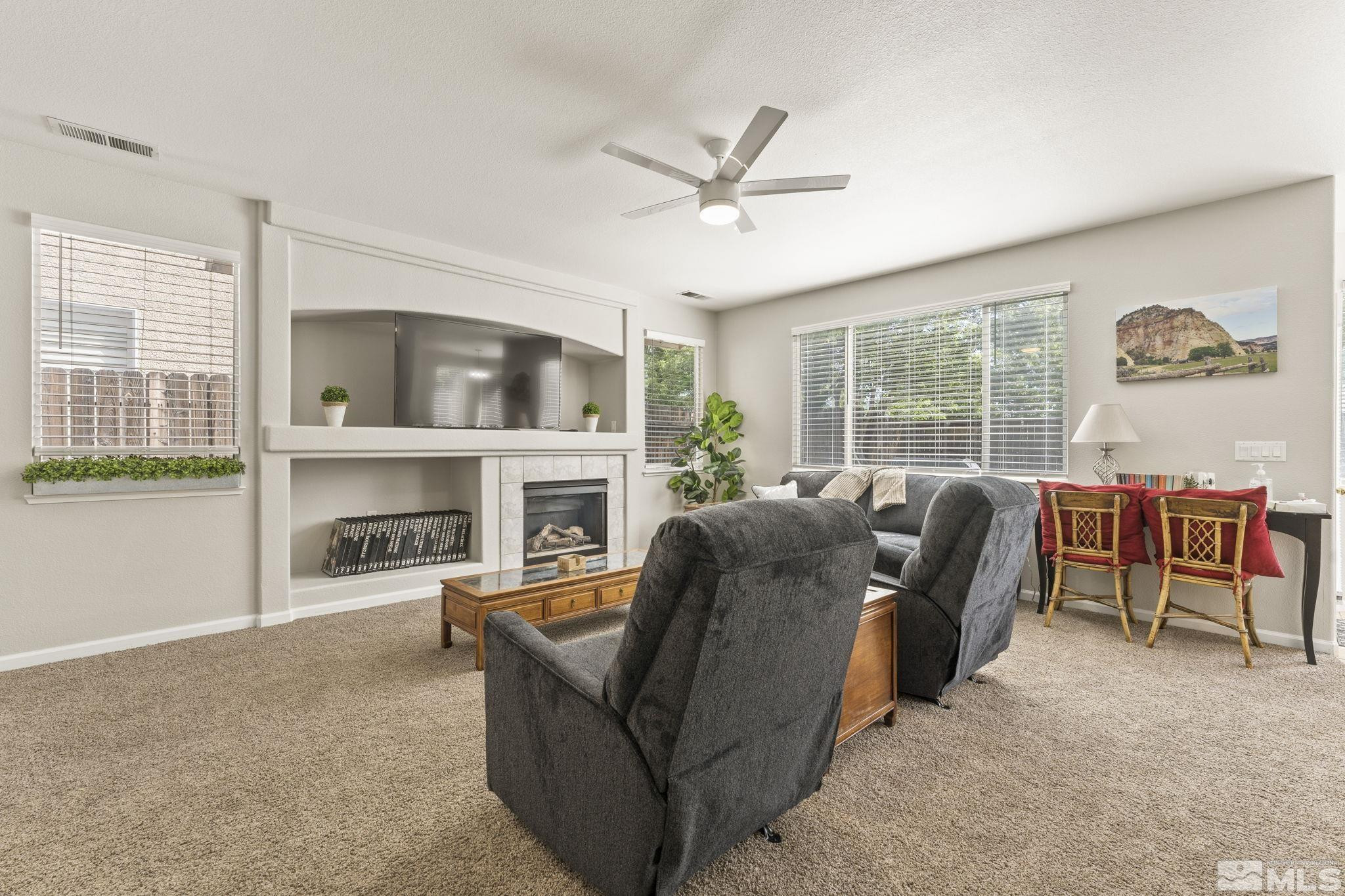 10640 Arbor Way Reno, NV 89521 - Photo 4 of 37 a living room with furniture a fireplace and a floor to ceiling window