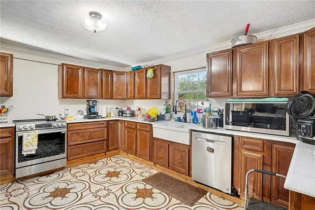 a kitchen with stainless steel appliances granite countertop a stove top oven a sink dishwasher and cabinets with wooden floor