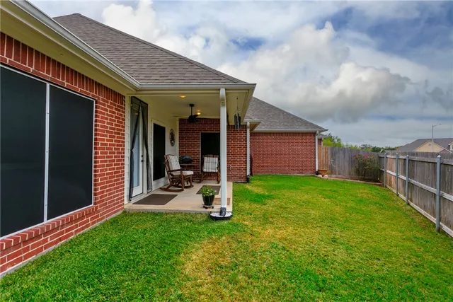 a view of a backyard with table and chairs and large tree