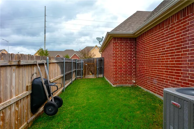 a view of a backyard with table and chairs and wooden fence