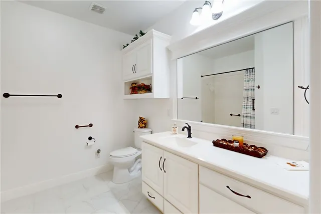 a bathroom with a sink a toilet and a mirror