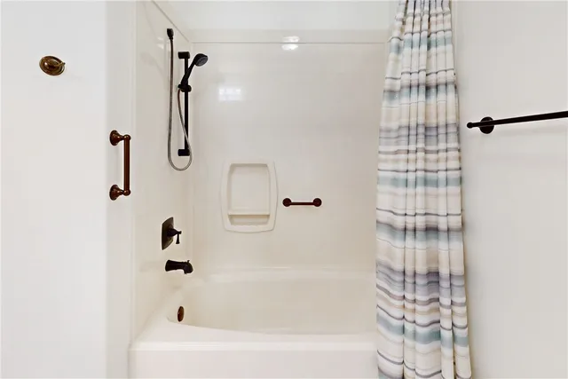 a bathroom with a bathtub and shower