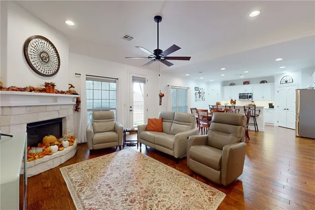 a living room with furniture a fireplace and a chandelier