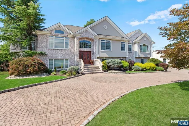 a front view of a house with a yard and potted plants