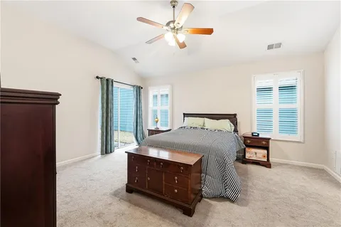 a bed sitting in a bedroom next to a window and a chandelier