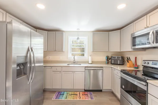 a kitchen with stainless steel appliances granite countertop a refrigerator sink and stove