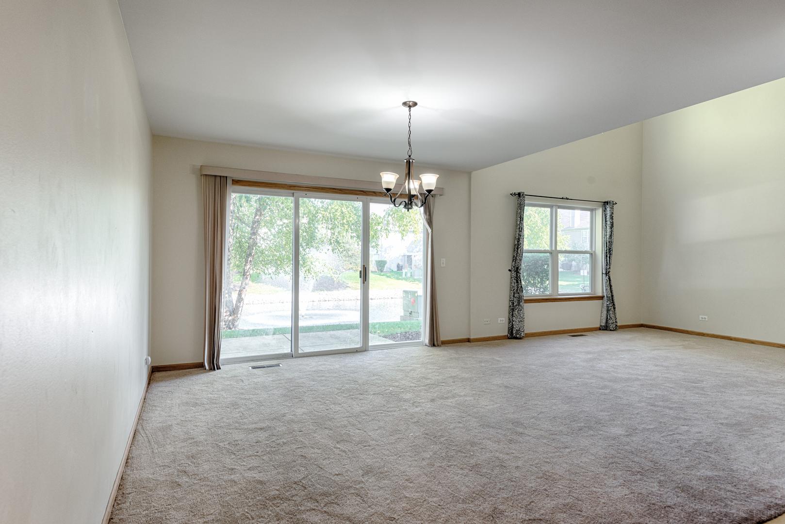 3261 Cool Springs Court Naperville, IL 60564 - Photo 22 of 25 an empty room with windows and chandelier