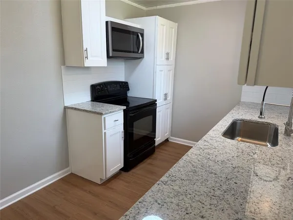 a kitchen with stainless steel appliances a stove a microwave and a sink