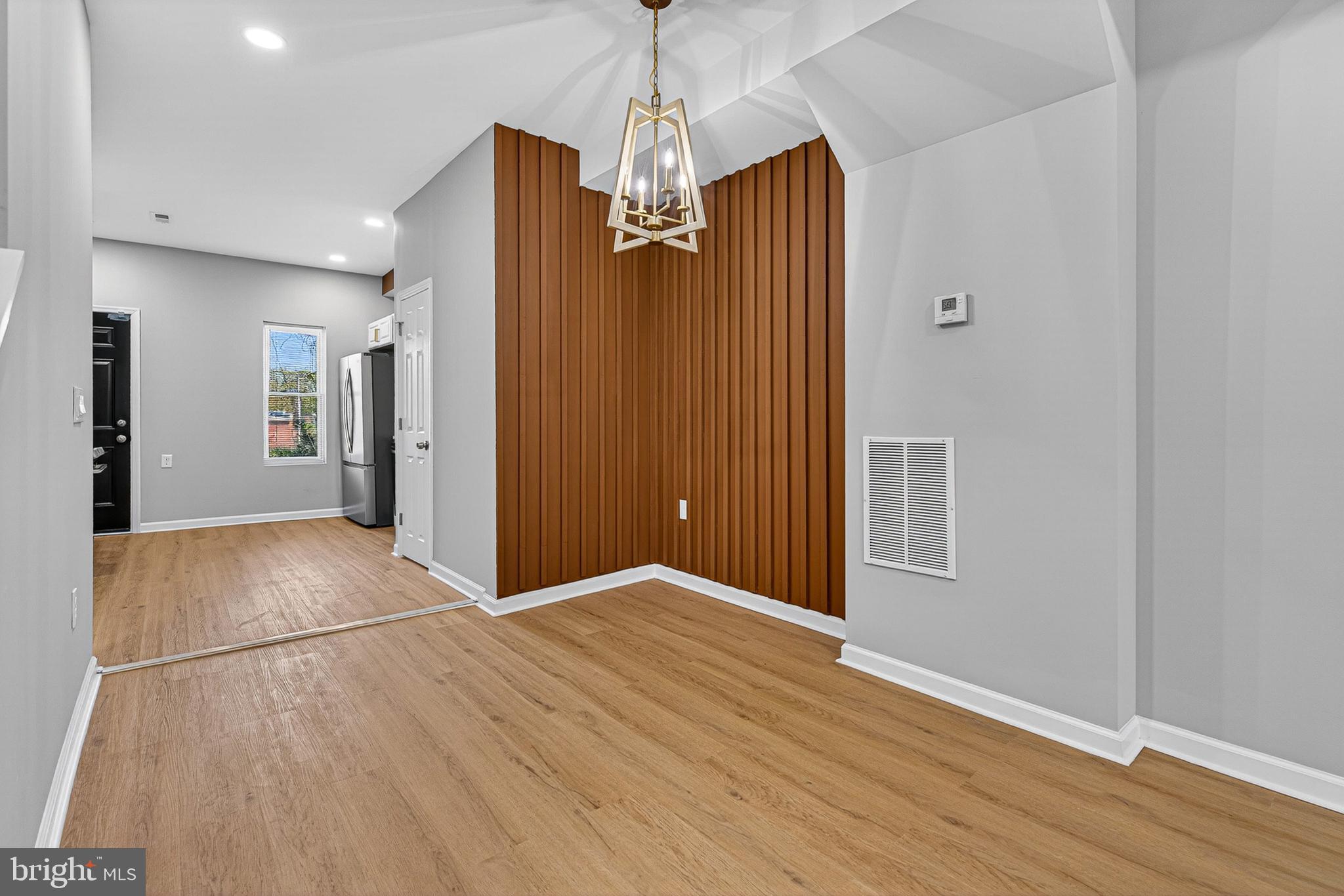 2518 West Fayette Street Baltimore, MD 21223 - Photo 8 of 32 a view of a livingroom with wooden floor staircase and a kitchen space