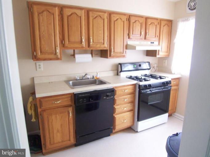 1948 Frames Road Dundalk, MD 21222 - Photo 2 of 6 a kitchen with stainless steel appliances granite countertop a stove a sink and a microwave