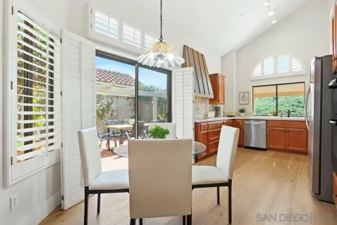 a dining room with furniture a chandelier and wooden floor