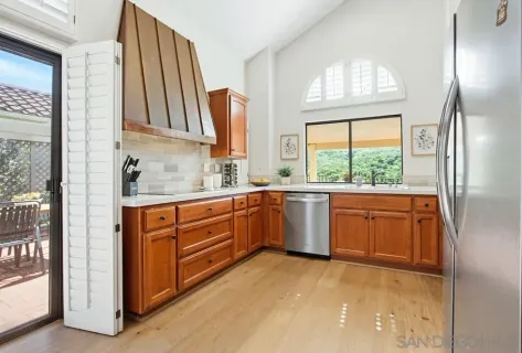 a kitchen with a sink window and cabinets