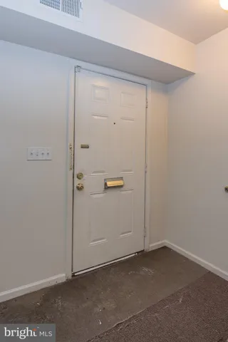 an empty room with white walls and stairs