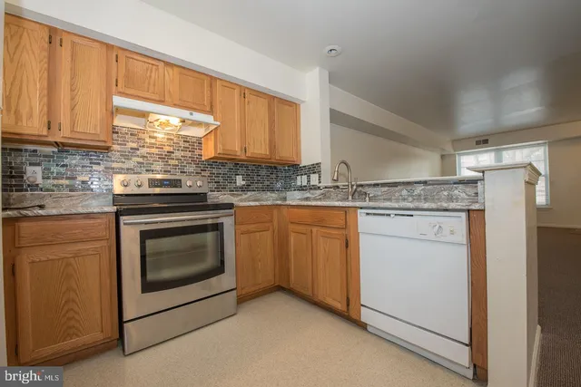 a kitchen with a stove a refrigerator and a cabinets