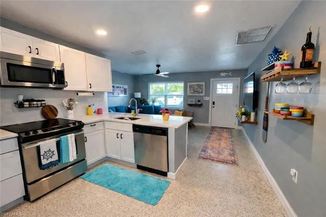 a kitchen with stainless steel appliances granite countertop a sink stove top oven and cabinets
