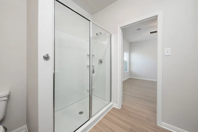 a bathroom with a shower and a glass door
