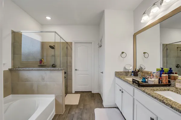 a bathroom with a granite countertop tub sink and mirror