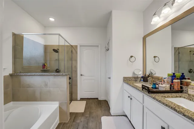 a bathroom with a granite countertop tub sink and mirror