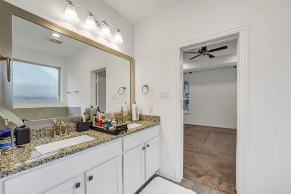 a bathroom with double vanity sinks and a mirror