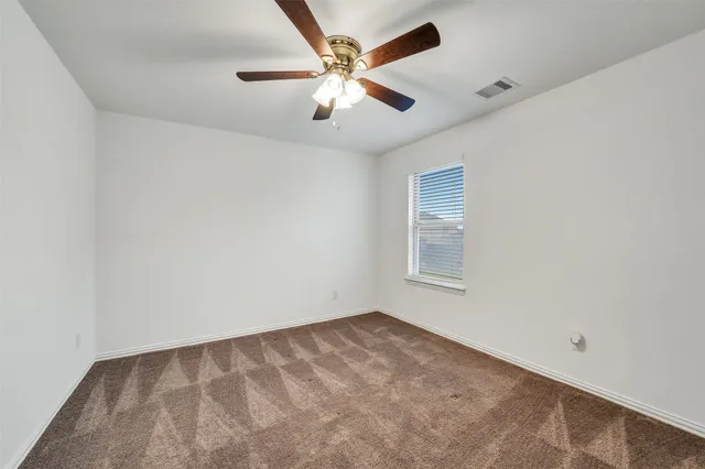 an empty room with closet and ceiling fan