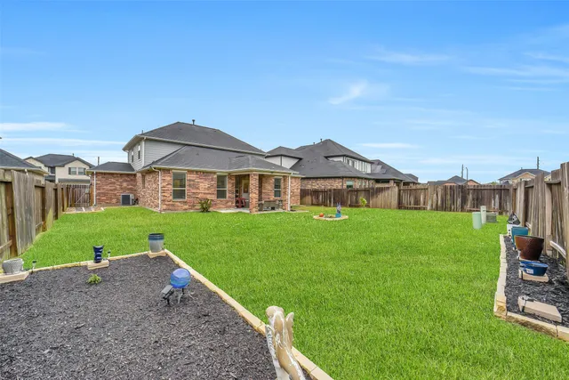 a view of a big house with a big yard and large trees