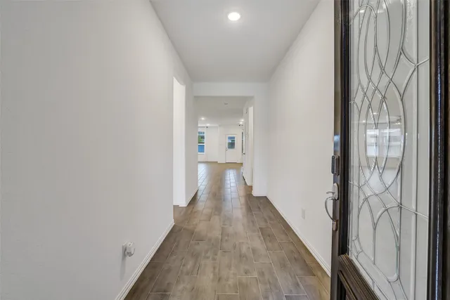 a view of a hallway with wooden floor