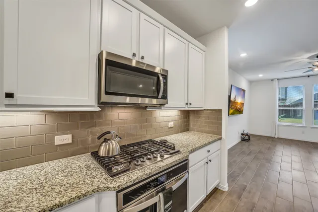 a kitchen with granite countertop a stove and a sink