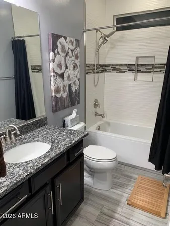 a bathroom with a granite countertop sink toilet and shower