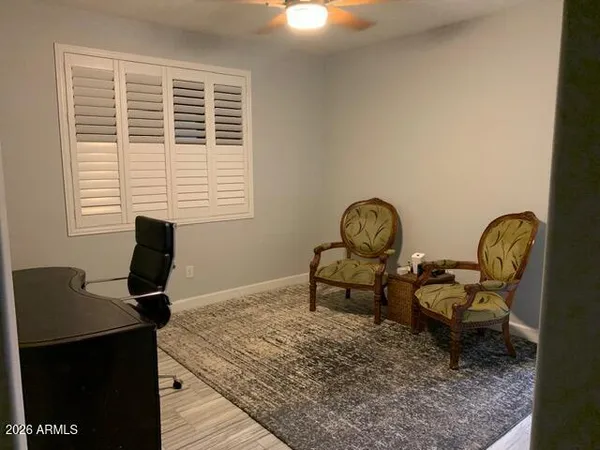 a view of a workspace room with furniture and windows